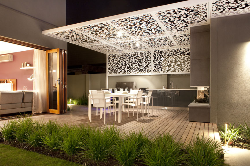 Contemporary out door entertaining area complete with a BBQ, fireplace and a white Gingko patterned laser cut pergola screen designed by Ian Barker Garden Design. 