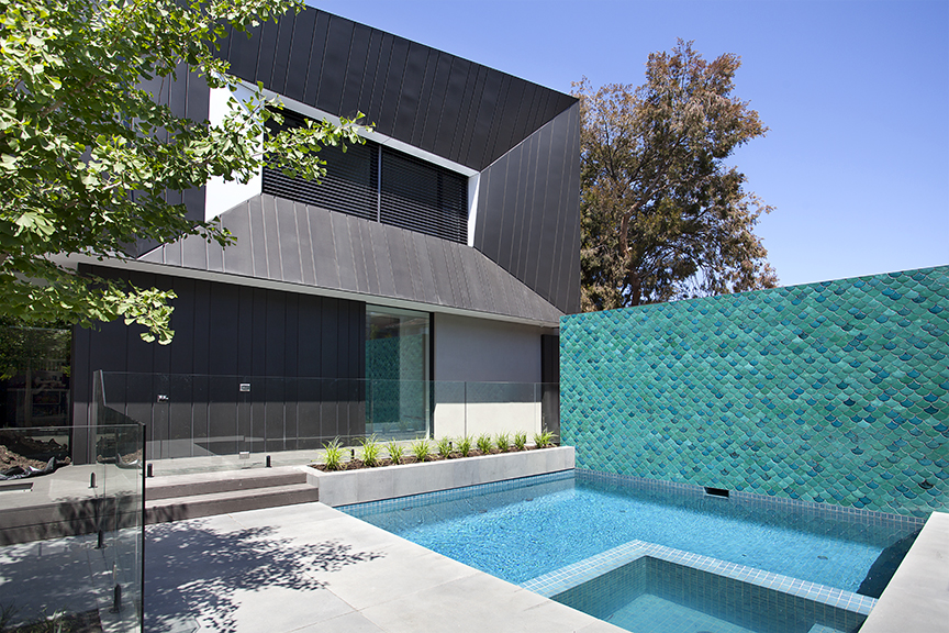 Blue green ceramic fish tiled feature wall perfectly complements the light blue plunge pool and modern architecture of the house on St Kilda with garden designed by Ian Barker Gardens