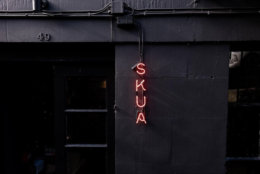 Skua lit up sign at the front of the restaurant.