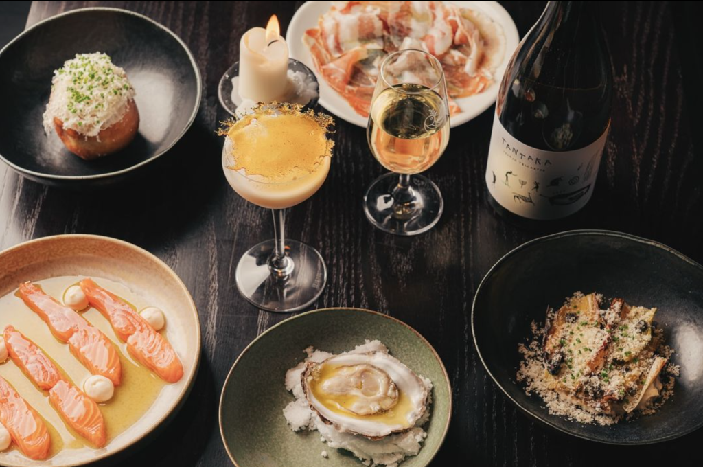 A dining table complete with multiple tasting dishes and drinks.